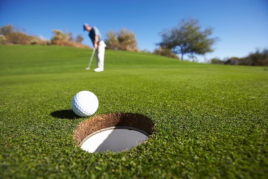 Male golfer putting on golf course